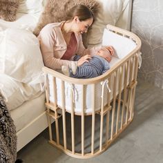 a woman is looking at a baby in a crib