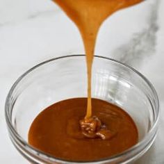 caramel sauce being poured into a glass bowl