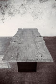 a wooden bench sitting on top of a cement floor