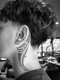 a woman with a tattoo on her neck and behind the ear is looking at something