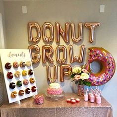 a table with donuts and doughnuts on it next to a sign that says donut grow