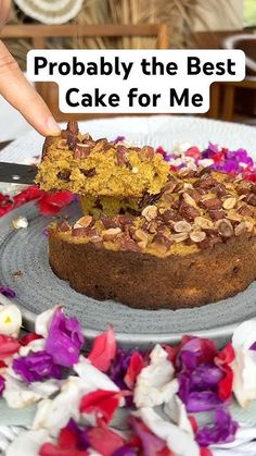 a person is cutting into a cake on a plate with flowers around it and the words probably the best cake for me