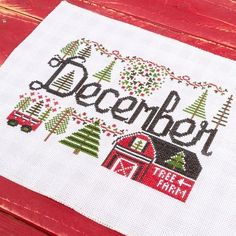 a cross stitch christmas card with the words december on it