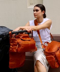 a woman sitting on a bench holding two bags