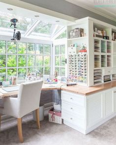 a large white desk sitting in the middle of a room with lots of windows on it