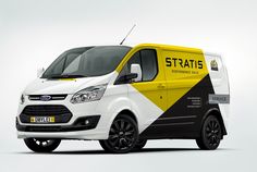 a white van with yellow and black stripes on it's side, parked in front of a gray background