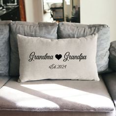 a couch with a pillow that says grandma and grandpa on the back in black ink