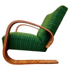 a wooden rocking chair with green fabric on the back and seat cushion, in front of a white background