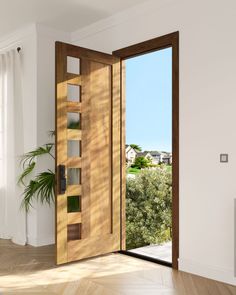 an open wooden door in a white room with wood flooring and potted plants