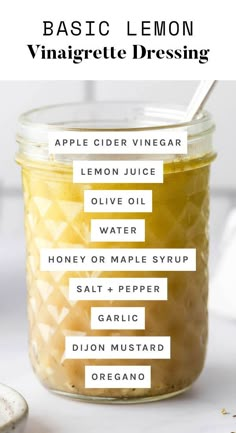 the ingredients for an apple cider vinegar dressing in a glass jar with a spoon