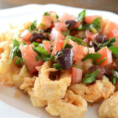 a white plate topped with cauliflower and olives