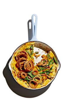 a pan filled with food sitting on top of a white counter next to a spatula