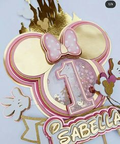 the first birthday cake topper is decorated with minnie mouse's ears and numbers