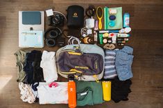 an assortment of personal items laid out on a wooden floor with the contents neatly organized