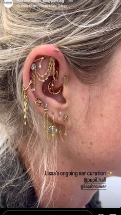 a woman wearing ear piercings with gold chains