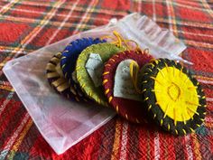 four small pieces of fabric sitting on top of a plaid cloth covered tablecloths