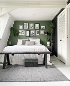 a bedroom with green walls and pictures on the wall