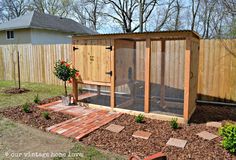 a small backyard with a wooden fence and outdoor shower in the back yard, surrounded by landscaping