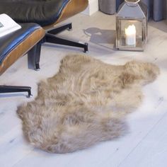 an animal skin rug is on the floor next to a chair and lamp in a living room