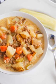 a white bowl filled with soup next to a spoon