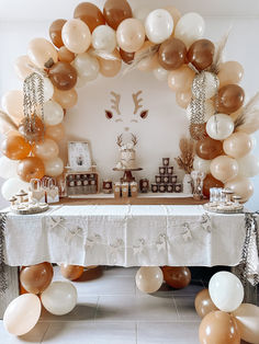 a table topped with lots of balloons and desserts