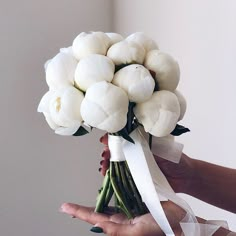 a person holding a bouquet of white flowers