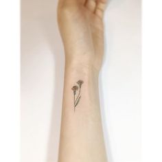 a woman's arm with a small flower tattoo on the left side of her wrist