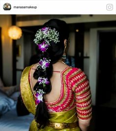 a woman in a yellow sari with purple flowers on her hair is looking into the distance