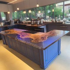 a large kitchen island with lights on it's sides and an island in the middle