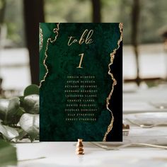 a table is set up with place cards and greenery