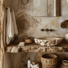 a stone sink in a bathroom next to a mirror and towel rack with towels on it