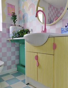 a bathroom with pink, yellow and green decor