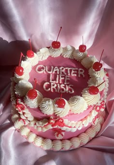 a pink cake with white frosting and cherries on top that says quarter life crisis