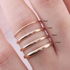 three different sizes of rings on someone's hand with measurements for each ring size