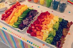 several trays filled with different types of fruits and veggies on a table