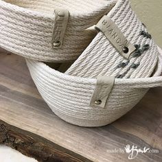 two white baskets sitting on top of a wooden table