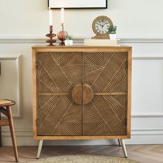 a wooden cabinet sitting next to a clock on top of a table in a living room