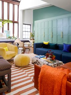 a living room filled with lots of furniture and colorful pillows on top of it's walls