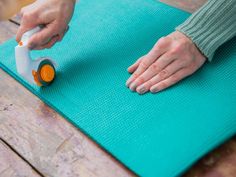 a person is doing yoga on a mat with an orange and white object in the middle