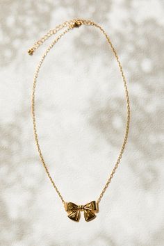 Add some whimsy to your jewelry collection with our Gold Bow Necklace. This playful piece features a delicate gold chain and a charming bow charm. With its convenient lobster closure, you'll never have to worry about losing this stylish accessory. Perfect for any occasion! Delicate Gold Chain, Made By Mary, Bow Charm, Preppy Jewelry, Bow Necklace, Bow Jewelry, Cute Bows, Stylish Accessories, Gold Chain