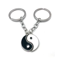 two black and white yin keychains on a white background, one with the letter s in it