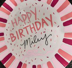 a pink and white plate with the words happy birthday miley written in black on it