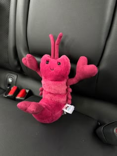 a pink stuffed animal sitting in the back seat of a car