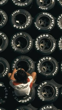 an overhead view of a man standing in front of a large pile of old tires