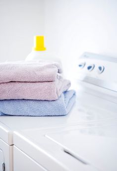 three towels stacked on top of each other in front of a washer and dryer