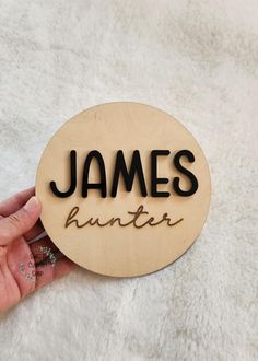 a hand holding a wooden sign that says james hunter