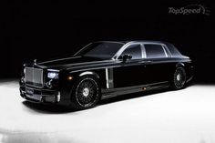 a black rolls royce parked in the dark