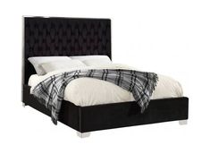 a bed with a black headboard and white sheets on it's side, in front of a white background