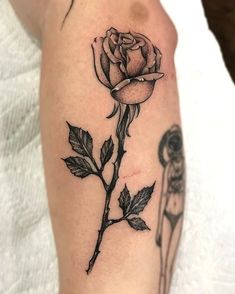 a black and white rose tattoo on the left arm, with two flowers in it