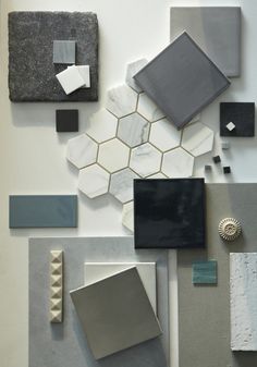 an assortment of different colors and shapes of tiles on the wall, including black, gray, white, and grey